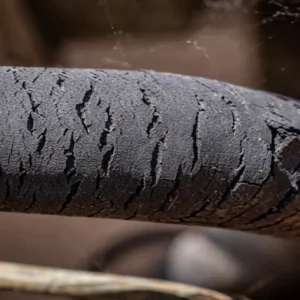Aged rubber hose with severe surface cracking caused by heat cycling and environmental exposure.